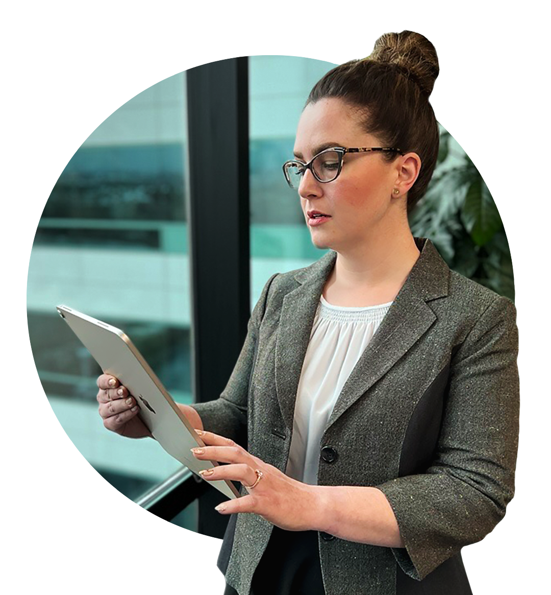 A female Bank employee stands looking at her iPad.